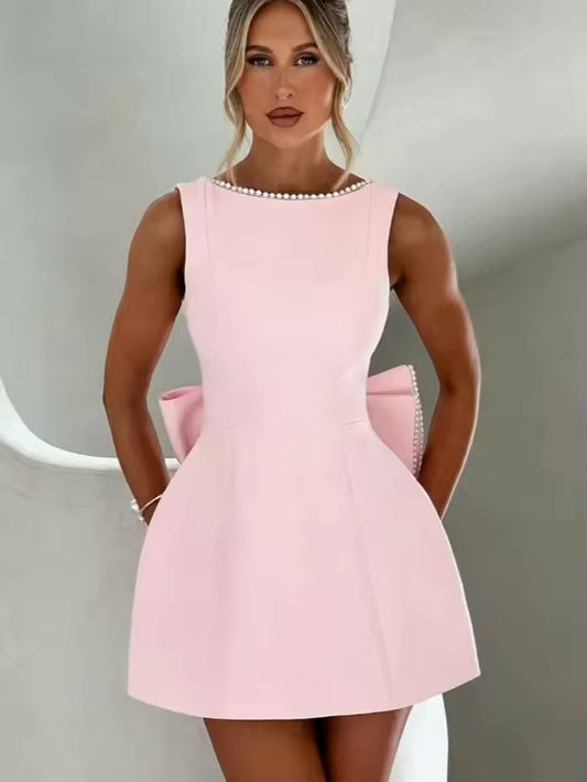 Vestido Mini Rosa em A com Design Costas Descobertas com Detalhes em Pérolas e Laço Grande