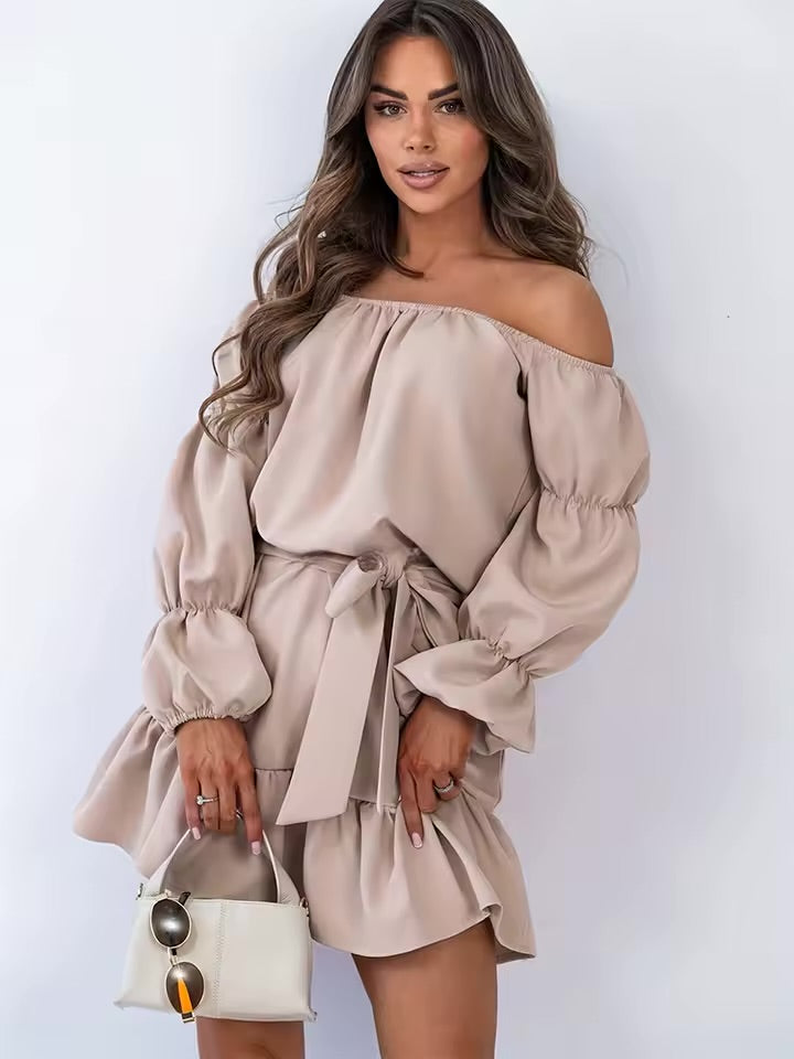 Este vestido na cor damasco tem um estilo doce e fresco. Apresenta mangas bufantes, cintura com laço e um bainha curta com babados.